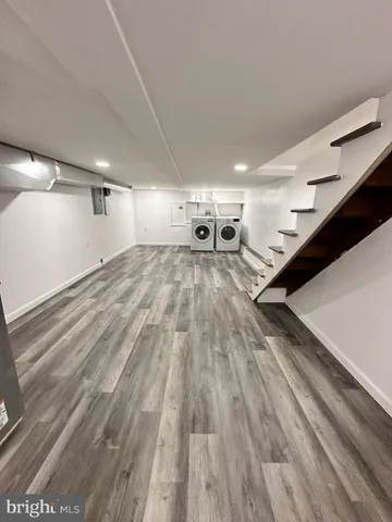 an empty room with wooden floor and fan