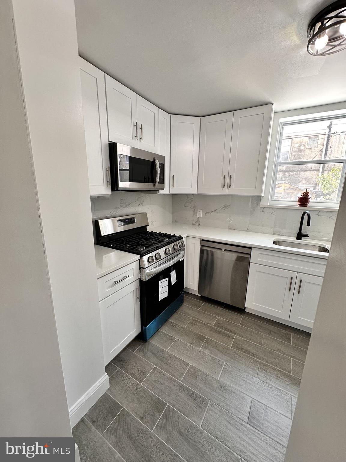 540 Manton Street Philadelphia, PA 19147 - Photo 5 of 25 a kitchen with stainless steel appliances a sink a stove a microwave a sink a refrigerator and cabinets