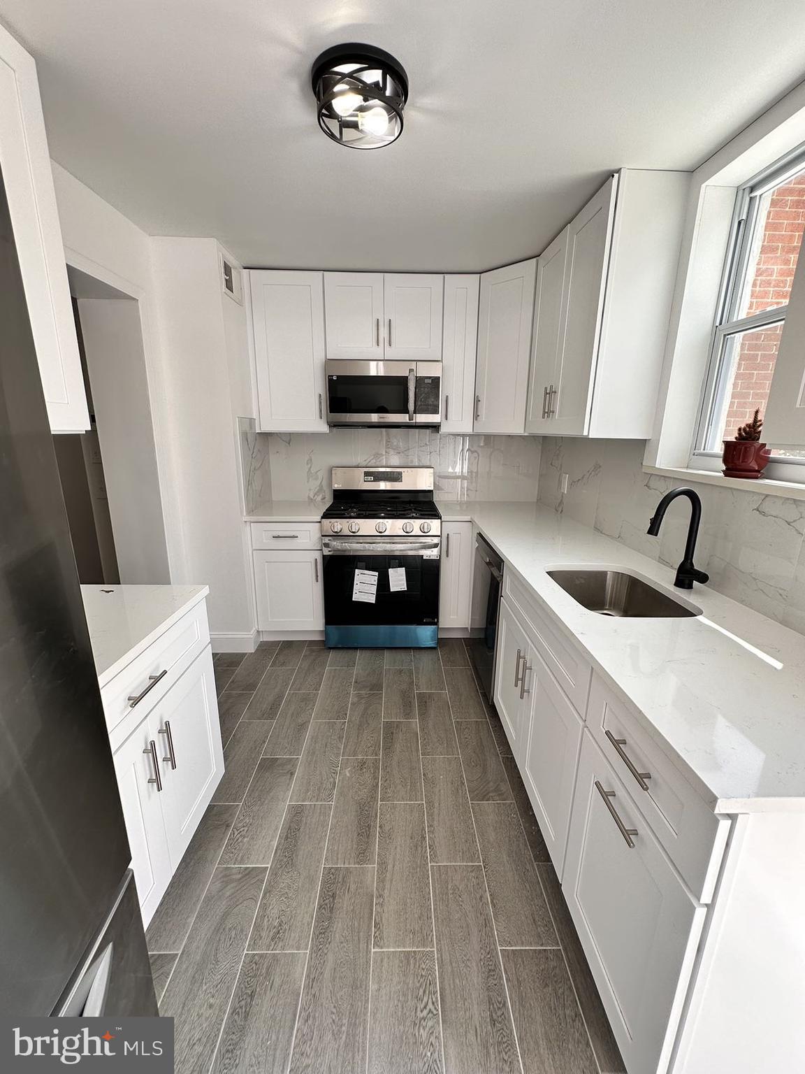 540 Manton Street Philadelphia, PA 19147 - Photo 7 of 25 a kitchen with a sink a stove top oven and cabinetry