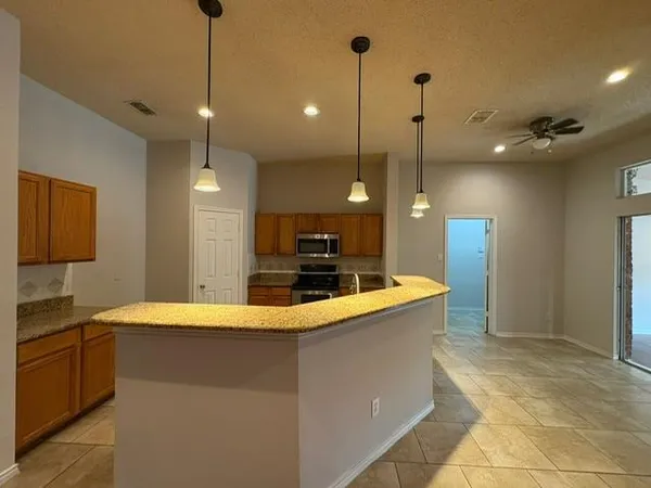 a kitchen with stainless steel appliances granite countertop a sink a stove and a refrigerator