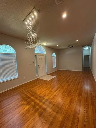 a view of empty room with wooden floor