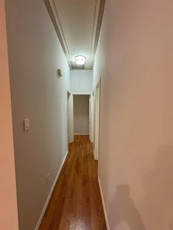 a view of a hallway with wooden floor