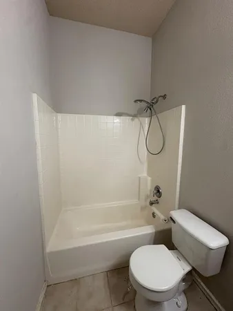 a white toilet and tub sitting next to a bathroom sink