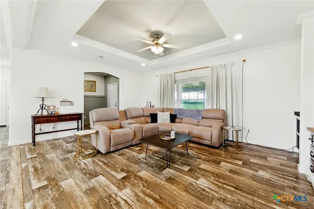 a view of a hallway with wooden floor and a bathroom