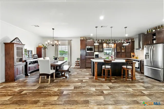 a kitchen with kitchen island a stove a counter top space a sink and cabinets