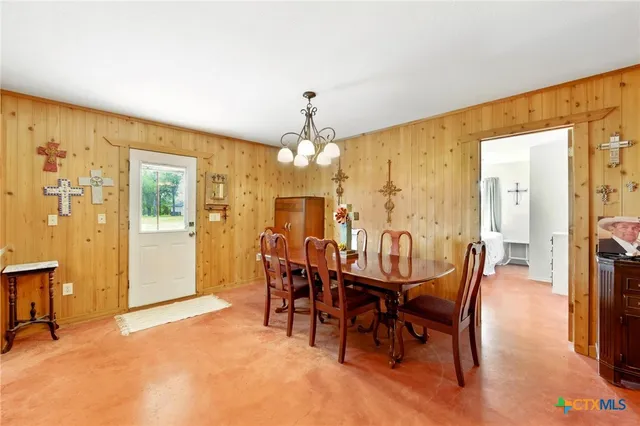 a kitchen with a table chairs refrigerator and cabinets