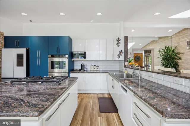 a large kitchen with stainless steel appliances granite countertop a large counter top and a stove top oven