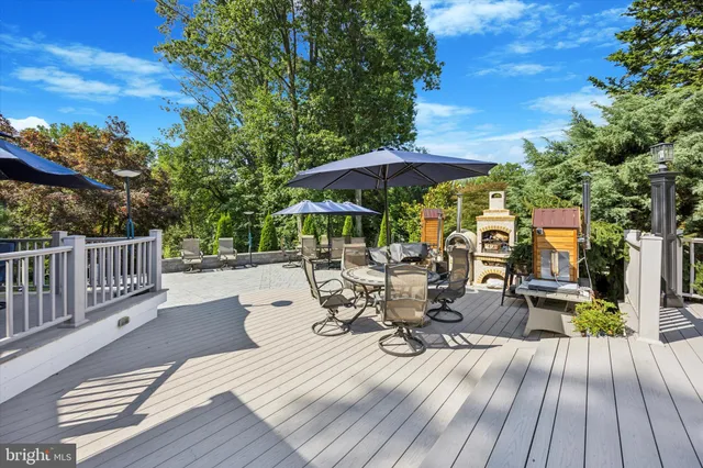 a view of a patio with a table and chairs under an umbrella with wooden fence