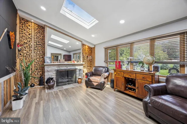 a living room with furniture a fireplace and a floor to ceiling window