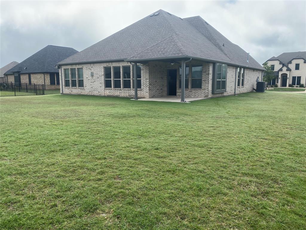 209 Johnson Street Granbury, TX 76048 - Photo 39 of 40 Rear view of house featuring a patio and a lawn