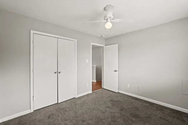 a view of an empty room with a chandelier fan
