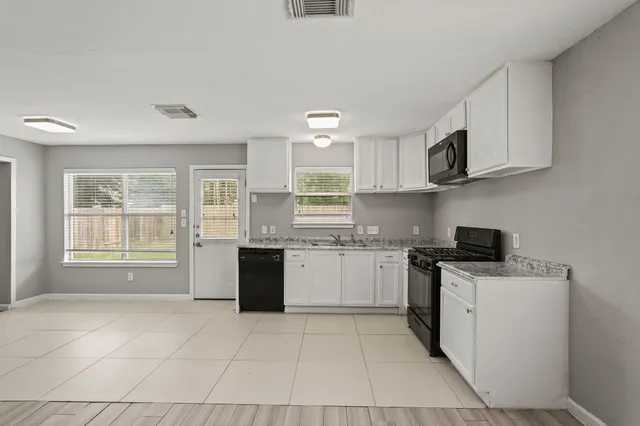 a kitchen with stainless steel appliances granite countertop a stove a sink and a microwave