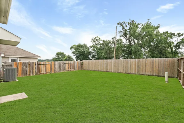 a view of backyard with wooden fence