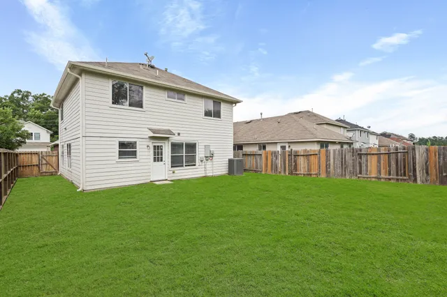 a view of a yard in front of a house with large trees