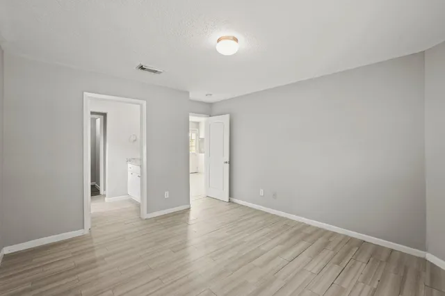 a view of an empty room with wooden floor