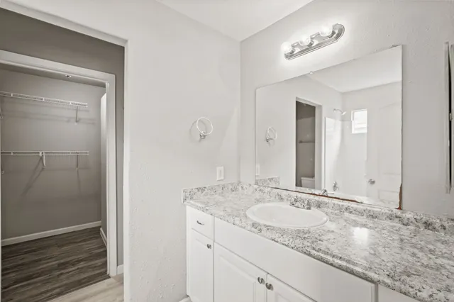 a bathroom with a granite countertop sink and a mirror
