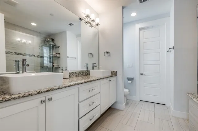 a bathroom with a granite countertop double vanity sink mirror bathtub and shower