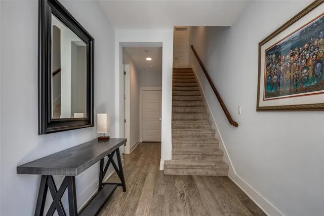 a view of a hallway with wooden floor and staircase