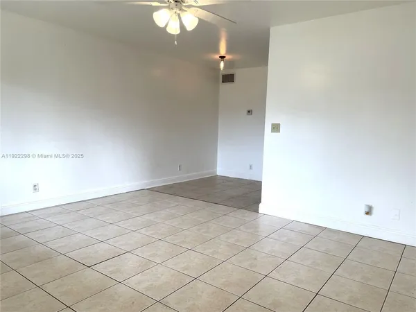 an empty room with a chandelier fan