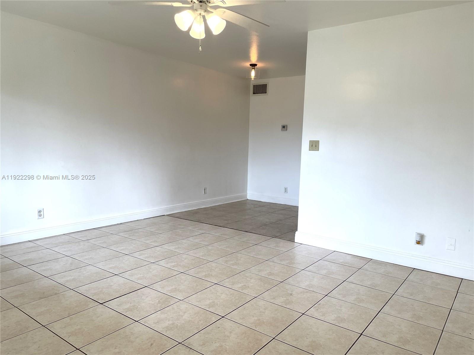 2121 Northeast 40th Court, Unit 2 Lighthouse Point, FL 33064 - Photo 3 of 11 an empty room with a chandelier fan