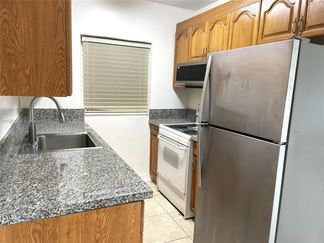 a kitchen with a refrigerator and a sink