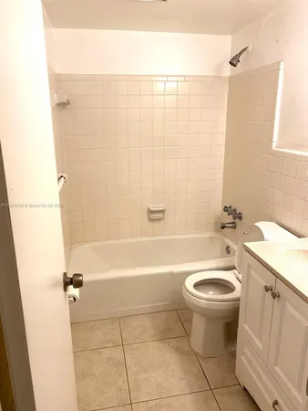 a bathroom with a sink a toilet a mirror a bathtub and shower