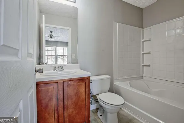 a bathroom with a granite countertop toilet a sink and bathtub