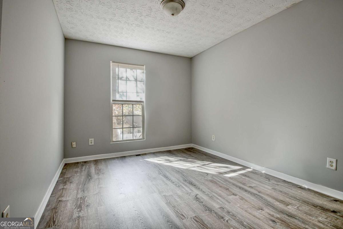 1915 Grove Way Hampton, GA 30228 - Photo 17 of 25 a view of an empty room with wooden floor and a window