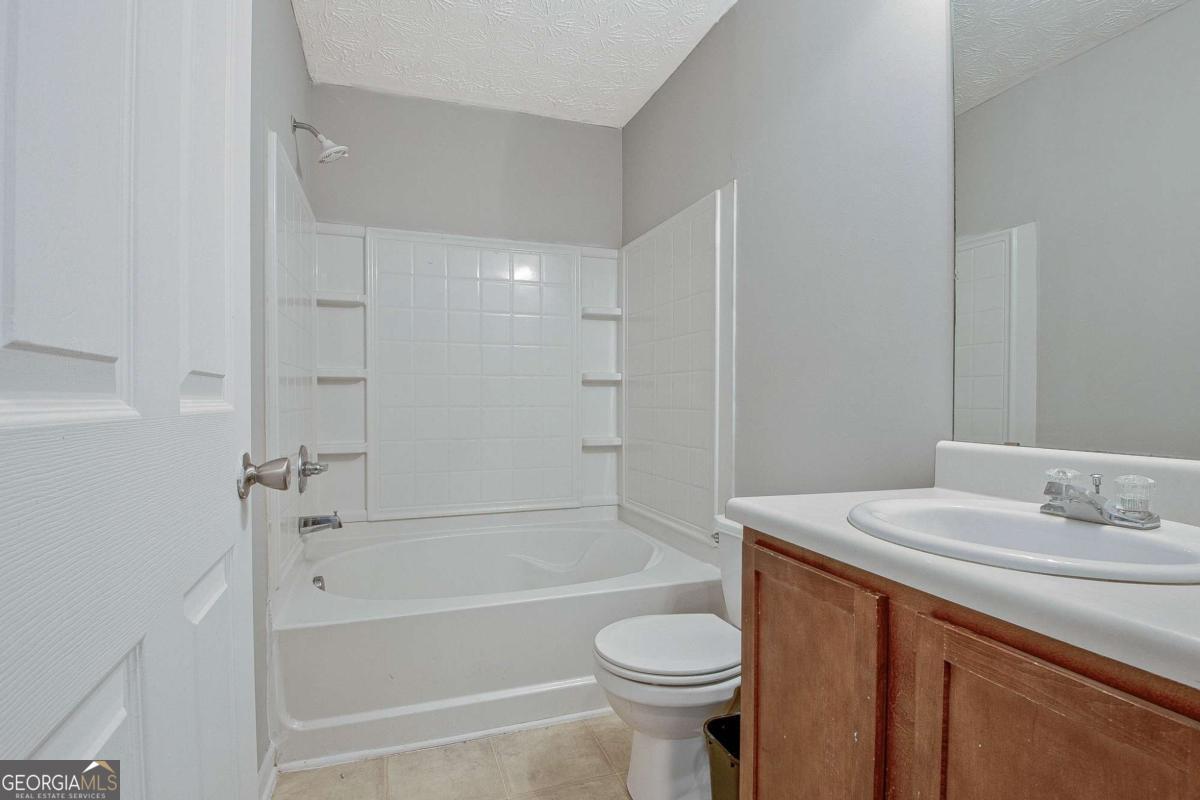 1915 Grove Way Hampton, GA 30228 - Photo 19 of 25 a bathroom with a sink toilet and shower