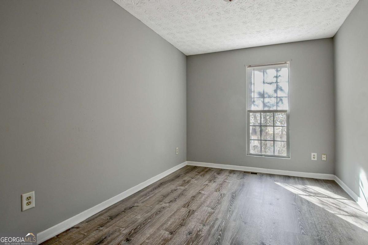 1915 Grove Way Hampton, GA 30228 - Photo 20 of 25 an empty room with wooden floor and windows