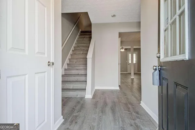 a view of a hallway with wooden floor and staircase