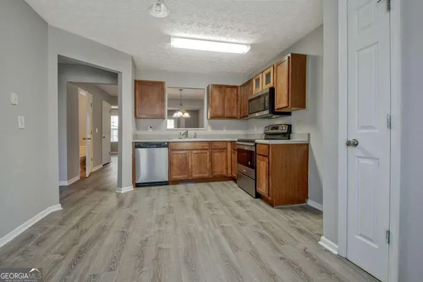 a large kitchen with stainless steel appliances granite countertop a stove and a sink