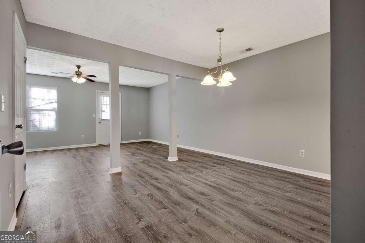 1915 Grove Way Hampton, GA 30228 - Photo 9 of 25 wooden floor in an empty room with a window