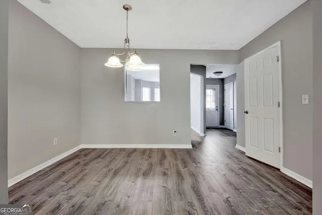 a view of a room with wooden floor and chandelier