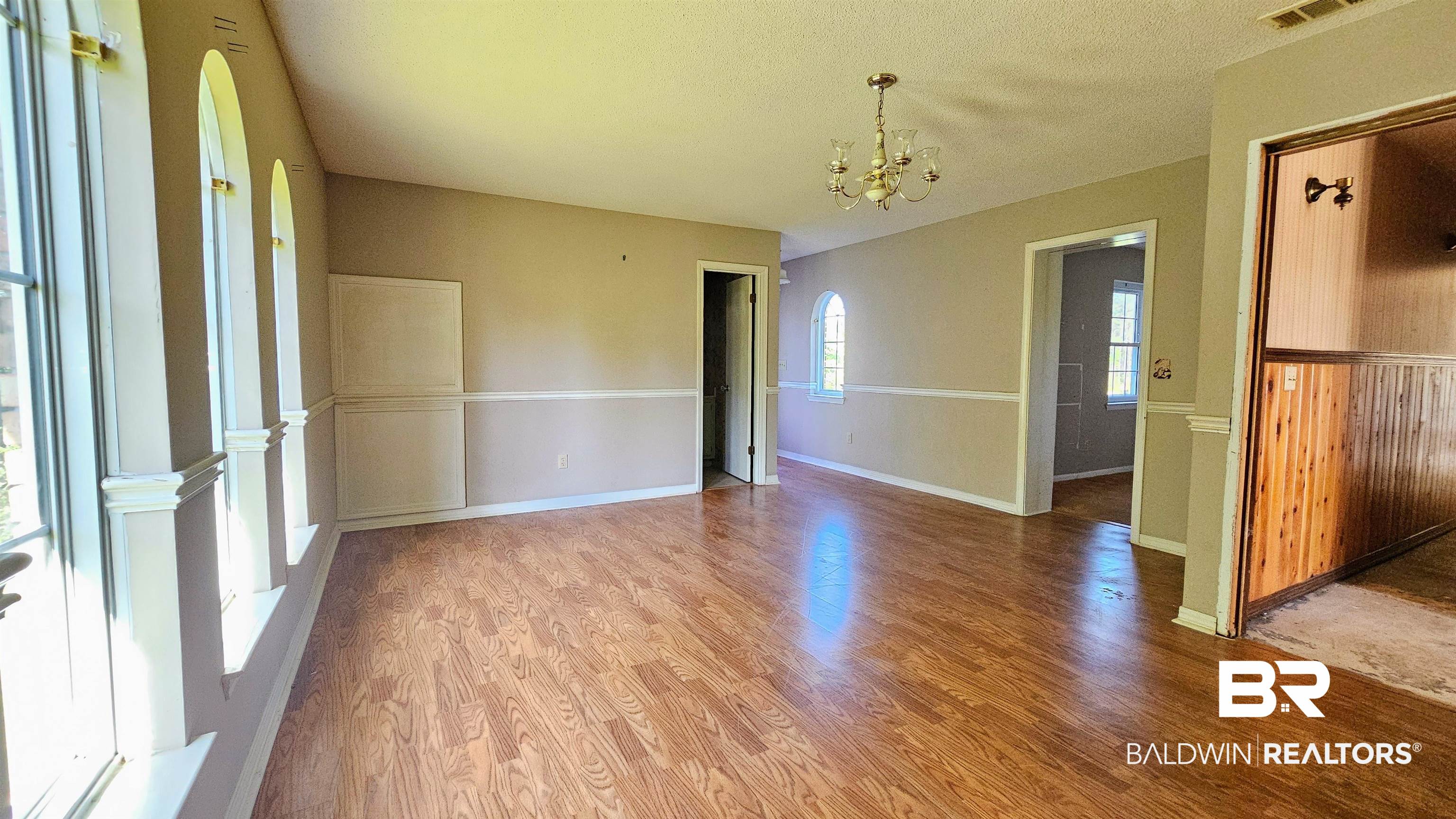 18824 Highway 41 Brewton, AL 36426 - Photo 31 of 40 Spacious interior room featuring wood-finish flooring, arched windows, and a classic chandelier