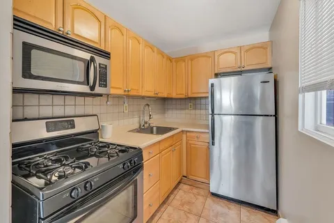 a kitchen with a stove a refrigerator and cabinets