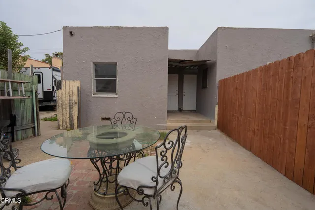 a backyard of a house with table and chairs