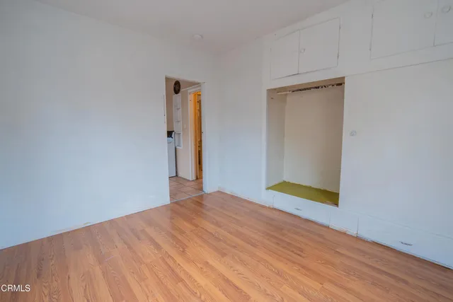 a view of an empty room with wooden floor