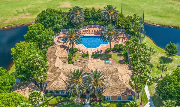 an aerial view of a house with a yard and lake view