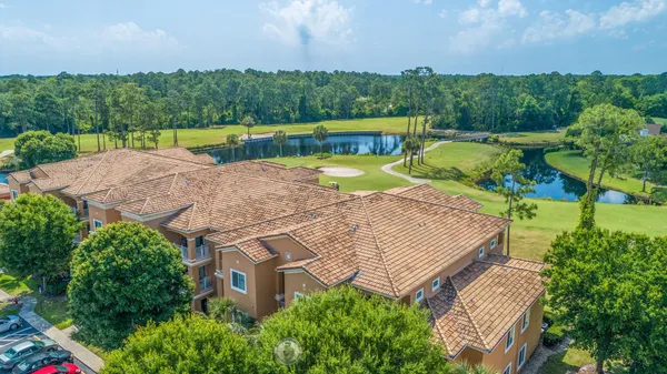 an aerial view of a house with a garden and lake view