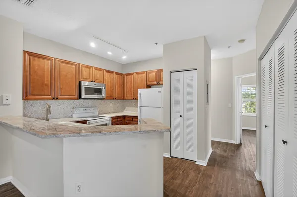 a kitchen with stainless steel appliances granite countertop a refrigerator sink and microwave