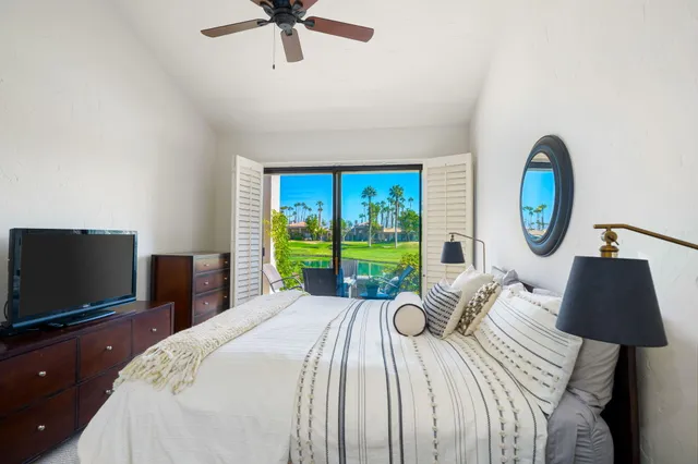 a bed room with a bed a television and a large window