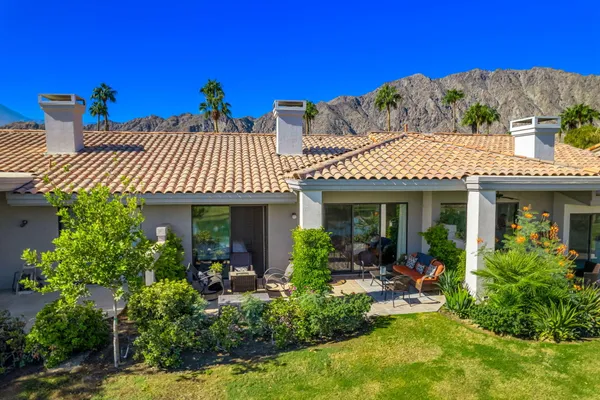 a view of a house with sitting area and garden