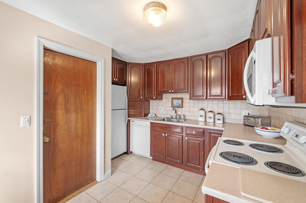 68 Preston Street, Unit 9D Wakefield, MA 01880 - Photo 11 of 29 a kitchen with stainless steel appliances granite countertop a refrigerator sink and cabinets