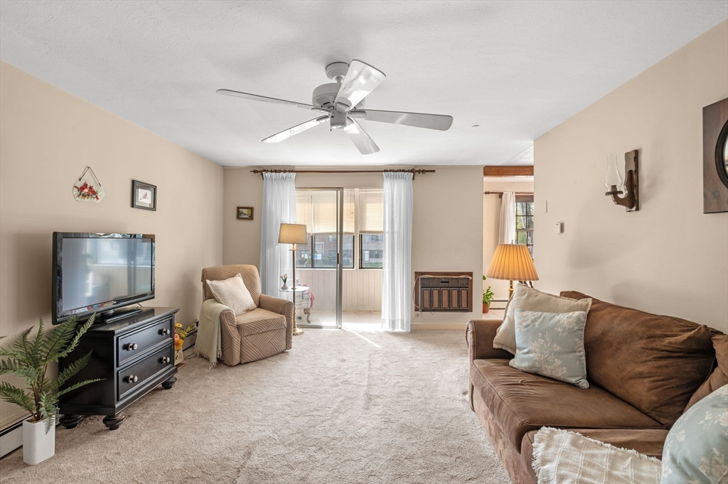 68 Preston Street, Unit 9D Wakefield, MA 01880 - Photo 3 of 29 a living room with furniture a ceiling fan and a flat screen tv