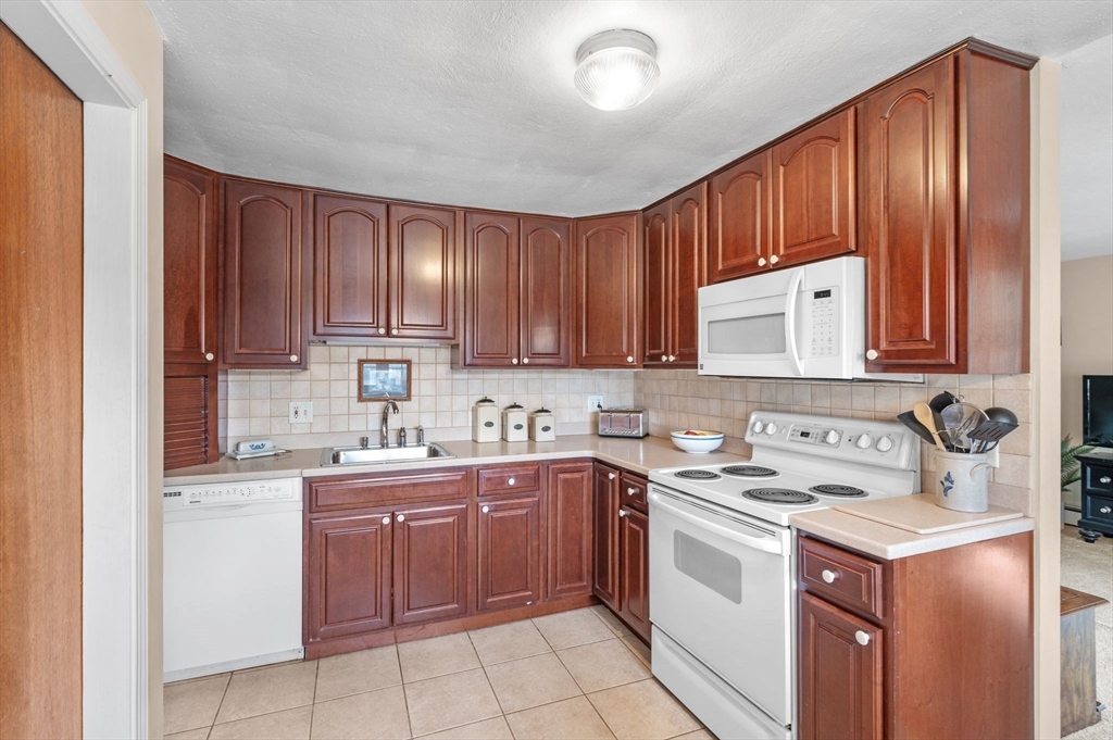 68 Preston Street, Unit 9D Wakefield, MA 01880 - Photo 10 of 29 a kitchen with a sink stove top oven and cabinets