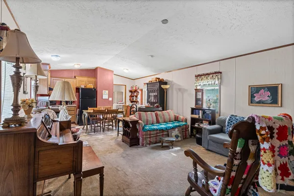a living room with furniture kitchen view and a large window