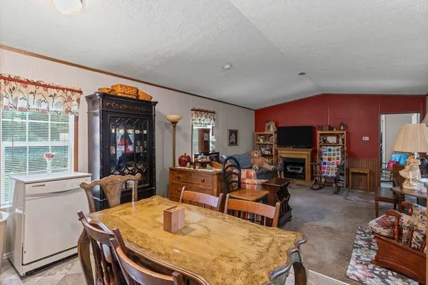 a kitchen with stainless steel appliances granite countertop a refrigerator a sink dishwasher a stove a dining table and chairs with wooden floor