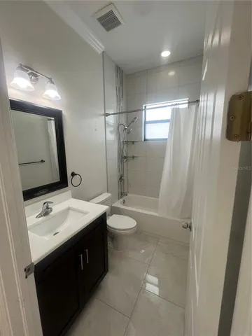 a bathroom with a double vanity sink toilet mirror and shower