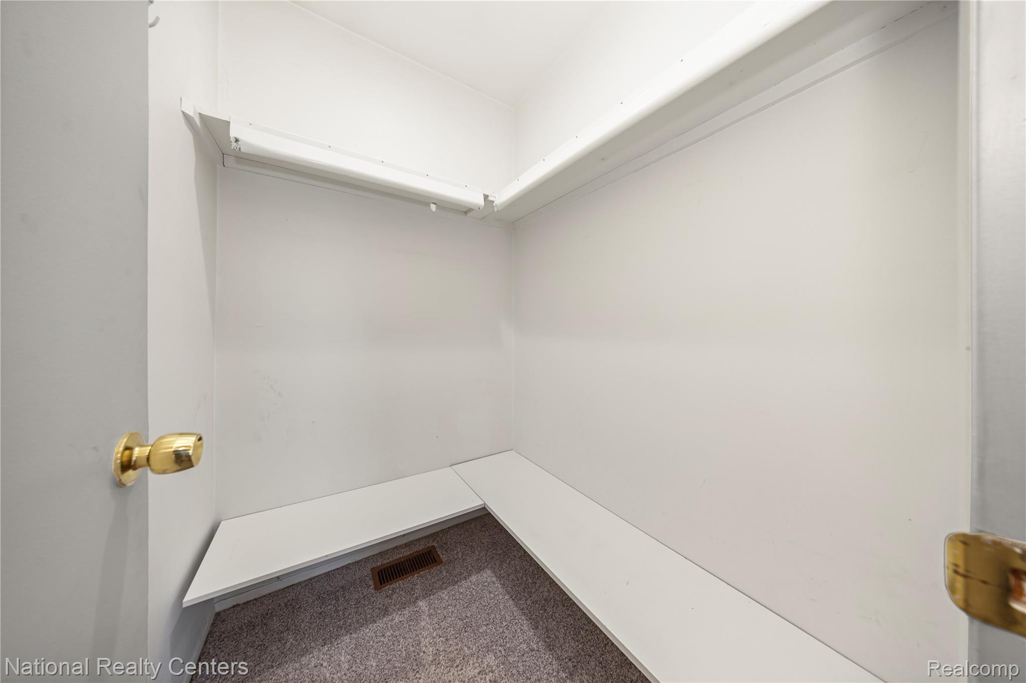 5274 East 14 Mile Road Warren, MI 48092 - Photo 20 of 31 Built-in shelving with hanging rod, L-shaped lower shelf, and carpet flooring